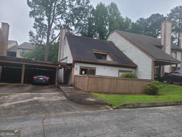 Charming townhome with a carport and quaint front yard, surrounded by mature trees in a quiet setting at 7 Willowick Dr, Lithonia, GA 30038