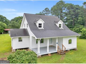 Charming home featuring a covered front porch, gray roof, and light gray siding, surrounded by lush landscaping at 778 Leguin Mill Rd, Locust Grove, GA 30248
