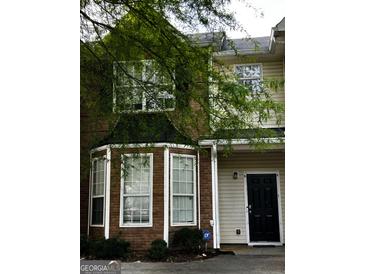 Traditional-style home with red brick and beige siding, black front door, and professionally monitored security system at 11313 Michelle Way, Hampton, GA 30228