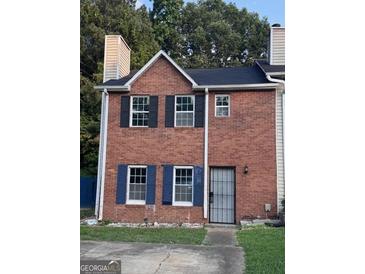 Charming two-story brick home with a well-maintained front yard and a secure metal gate at 990 Hickory Bend Rd, Atlanta, GA 30349