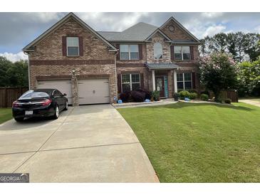 Charming two-story brick home with a well-manicured lawn and a two-car garage at 1141 Norsworthy Ml, Hampton, GA 30228