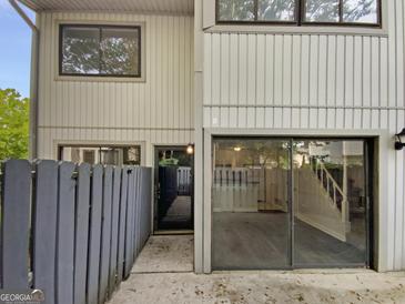 Charming townhouse featuring a gray exterior, inviting front door, and sliding glass doors at 1480 D Ne Pine Log Rd # D, Conyers, GA 30012