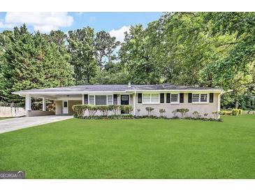 Charming one-story home with a long driveway and well-manicured lawn and front bushes at 3403 Linda Dr, Lithia Springs, GA 30122
