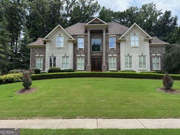 Stately home with a manicured lawn, brick and stucco facade, and grand entrance with columns at 2675 Bolton Abbey Sw Dr, Marietta, GA 30064