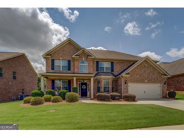 Charming brick two-story home with manicured lawn and inviting curb appeal on a sunny day at 312 Relative Trl, Mcdonough, GA 30253