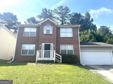 Charming brick two-story home with an attached garage and a well-maintained lawn at 755 Kilkenny Cir, Lithonia, GA 30058