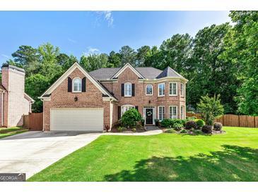 Charming brick home featuring a manicured lawn, two-car garage, and inviting front entrance at 1605 Cascade Overlook, Peachtree City, GA 30269