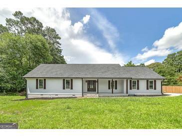 Charming ranch-style home with white siding, a covered front porch, and a well-manicured lawn at 858 Pates Creek Rd, Stockbridge, GA 30281
