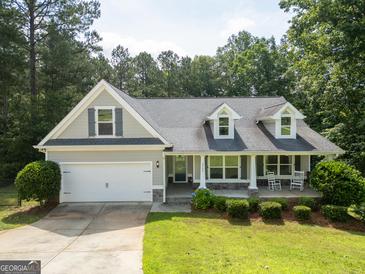 Charming home with a two-car garage, welcoming front porch, and well-manicured lawn at 2565 Aaron Ct, Loganville, GA 30052