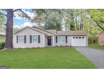 Charming single-story home with manicured lawn, neutral siding, black shutters, and an attached garage at 410 Tarragon Sw Way, Atlanta, GA 30331