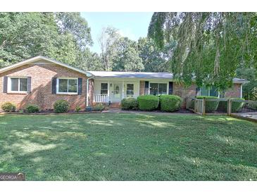Charming brick home featuring a well-manicured front yard and neatly trimmed landscaping at 110 Heatherwood Dr, Fayetteville, GA 30215