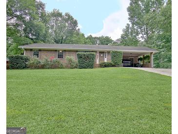 Charming brick home with a well-manicured front yard and covered parking at 260 Sharon Dr, Fayetteville, GA 30214