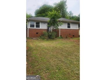 Charming one-story home featuring a brick facade, well-tended lawn and mature trees at 250 Jonesboro Rd, Jonesboro, GA 30236