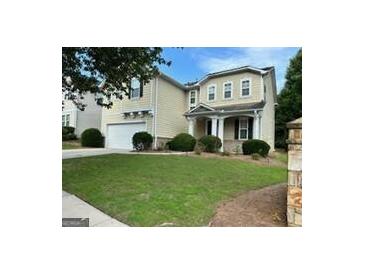 Charming two-story home with manicured lawn and attached two-car garage at 6131 Sparkling Cove Ln, Buford, GA 30518
