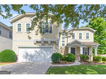 Charming two-story home featuring a well-manicured lawn and an attached two-car garage at 6131 Sparkling Cove Ln, Buford, GA 30518