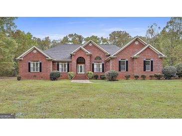 Charming single-story brick home with a well-manicured lawn and mature landscaping, perfect for curb appeal at 3530 Highway 81 W, Hampton, GA 30228