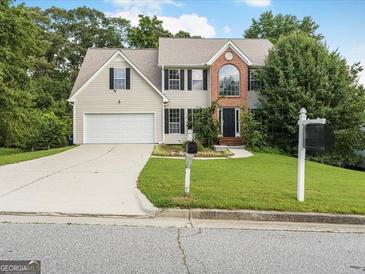 Charming two-story home featuring a well-manicured lawn, brick accents, and an attached two-car garage at 942 Marta Crane Dr, Lawrenceville, GA 30045