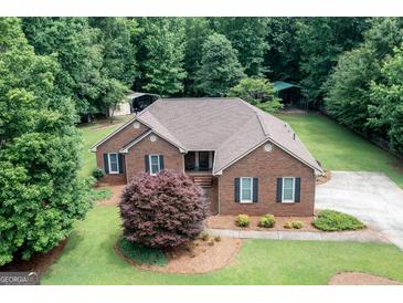 Charming brick home with well-maintained landscaping and a sprawling green lawn at 280 Ridgemont Dr, Fayetteville, GA 30215