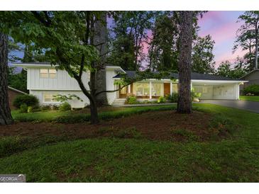 Charming exterior of home with lush landscaping and inviting front porch with wooded trees at 2944 Braithwood Ne Ct, Atlanta, GA 30345