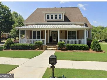 Charming home featuring a welcoming front porch and meticulously landscaped lawn and beautiful plantings at 150 Campaign Trl, Fayetteville, GA 30214