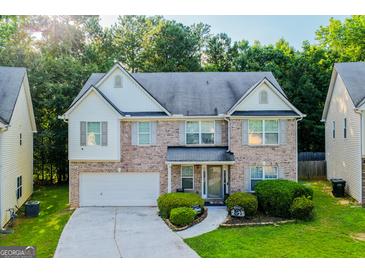 Charming two-story home with a brick facade, well-manicured lawn, and an attached two-car garage at 4613 Beau Point Ct, Snellville, GA 30039