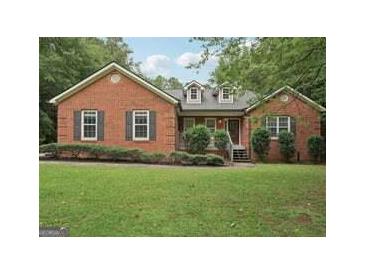 Charming brick home featuring a well-manicured lawn and classic architectural details at 140 Alford Dr, Fayetteville, GA 30215