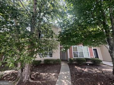Charming two-story home with a pathway and mature trees in the front yard at 160 Odyssey Turn, Conyers, GA 30012