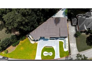 Stunning aerial view of a modern home featuring a manicured lawn and stylish circular driveway at 2401 Ne Greenglade Rd, Atlanta, GA 30345