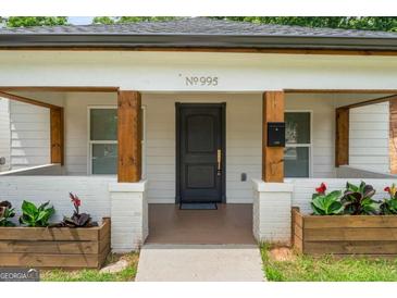 Inviting front porch with brick planters, wooden posts, and a charming entrance with the house number above the door at 995 Lena Nw St, Atlanta, GA 30314