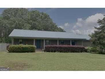 Charming brick ranch-style home with a metal roof, front porch, and mature landscaping at 260 Willis Rd, Sharpsburg, GA 30277