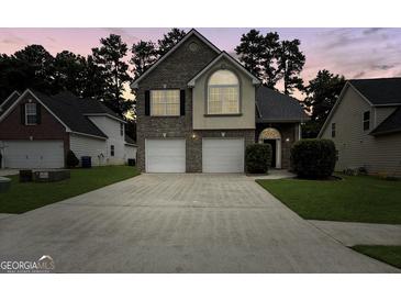 Charming two-story home boasts a brick facade, two-car garage, and well-manicured lawn at 120 Hawken Trl, Mcdonough, GA 30253