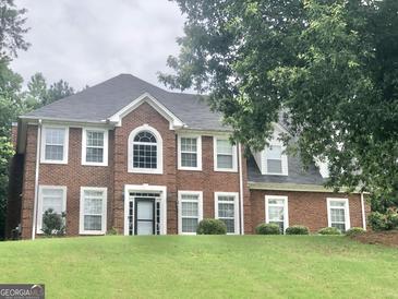 Traditional two-story brick home featuring an arched window and a well-manicured lawn at 1433 Cotton Sw Trl, Conyers, GA 30094