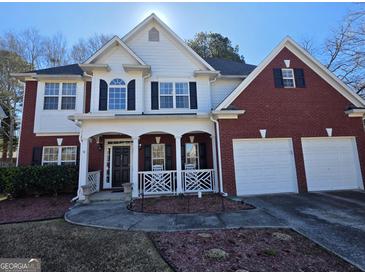 Charming two-story home with brick and siding, well-manicured lawn, and attached two-car garage at 5725 Lake Windsor Pkwy, Buford, GA 30518