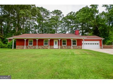Charming red home with a covered porch, stone accents, and a well-manicured lawn surrounded by mature trees at 125 Point View Ct, Tyrone, GA 30290