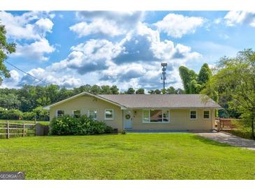 Well-maintained ranch style home featuring a lush lawn, mature trees, and a welcoming front porch at 1848 Winthrop Se Dr, Atlanta, GA 30316