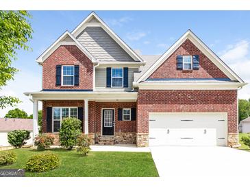 Charming two-story brick home with a well-manicured lawn and a two-car garage at 335 Autumn Bluff Dr, Lawrenceville, GA 30044