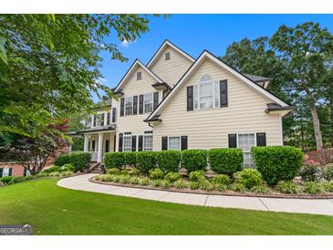 Two-story home with black shutters, manicured lawn and lovely, lush landscaping at 5833 Wembley Dr, Douglasville, GA 30135