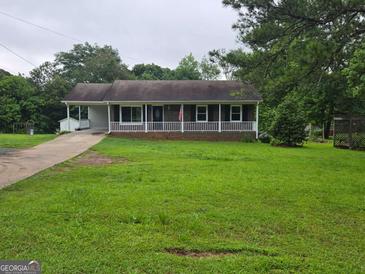 Charming single-story home with a covered porch and well-maintained front yard at 1997 Villa Rica Hwy, Dallas, GA 30157