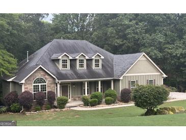 Charming one-story home with stone accents, a covered porch, and a beautifully landscaped front yard at 500 Barrington Farms Pkwy, Sharpsburg, GA 30277