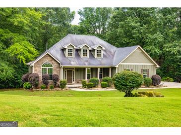 Charming home with a stone facade, inviting curb appeal, and lush green landscaping at 500 Barrington Farms Pkwy, Sharpsburg, GA 30277