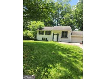 Charming one-story home featuring a spacious front yard and an attached garage at 6485 Boca Grande Blvd, Forest Park, GA 30297