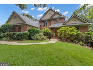 Charming brick home featuring a well-manicured lawn and mature landscaping at 821 Carnellian Ln, Peachtree City, GA 30269