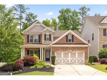 Charming two-story home featuring a manicured lawn and a three-car garage at 1220 Roswell Manor Cir, Roswell, GA 30076