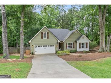 Charming home featuring a well-manicured lawn, inviting curb appeal, and attached two car garage at 15 Stonewood Way, Sharpsburg, GA 30277