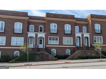 Brick townhomes feature black iron detailing, symmetrical windows, and raised entrances, adding to the curb appeal at 5139 Peachtree Road, Chamblee, GA 30341