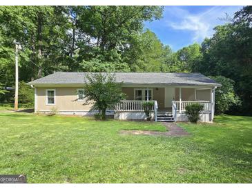 Charming single-story home featuring a welcoming front porch and a well-maintained green lawn at 465 Haynie Rd, Moreland, GA 30259
