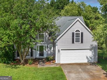 Charming two-story home with well-maintained lawn, mature trees and inviting front entrance at 404 Northwind Pl, Stockbridge, GA 30281