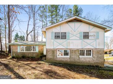 Charming two-story home features a brick and stucco exterior with light blue trim and several large windows at 2571 Beech St, Morrow, GA 30260