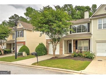 Charming townhome featuring a well-maintained front yard and a one-car garage at 1643 Jackson Way, Atlanta, GA 30318