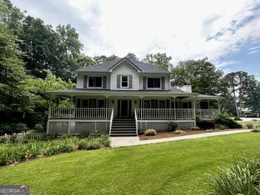 Charming two-story home with a large wraparound porch and well-manicured lawn at 3970 Governors Cir, Loganville, GA 30052